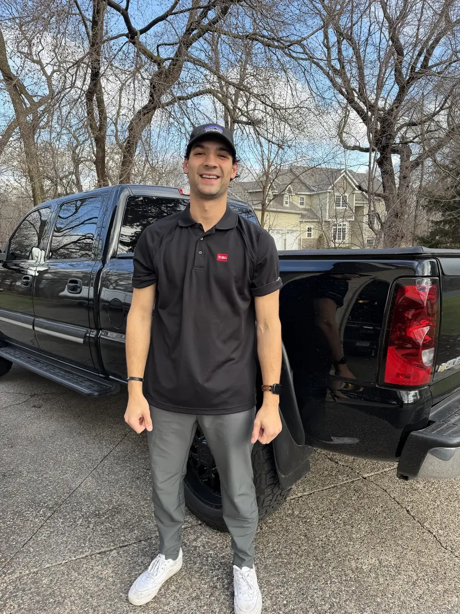 A Heads Up crew member smiling by the black work truck