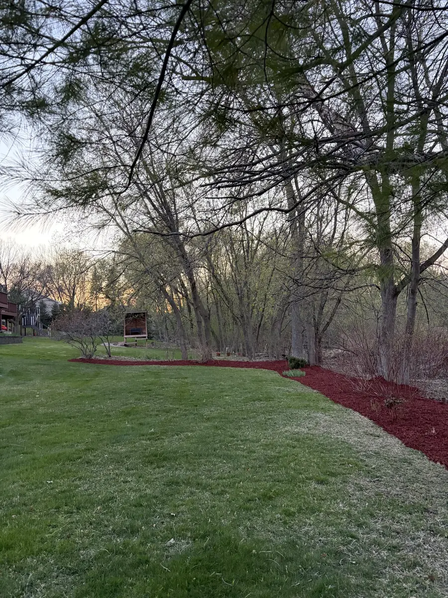 A tree line freshly spread with red mulch at the end of the day