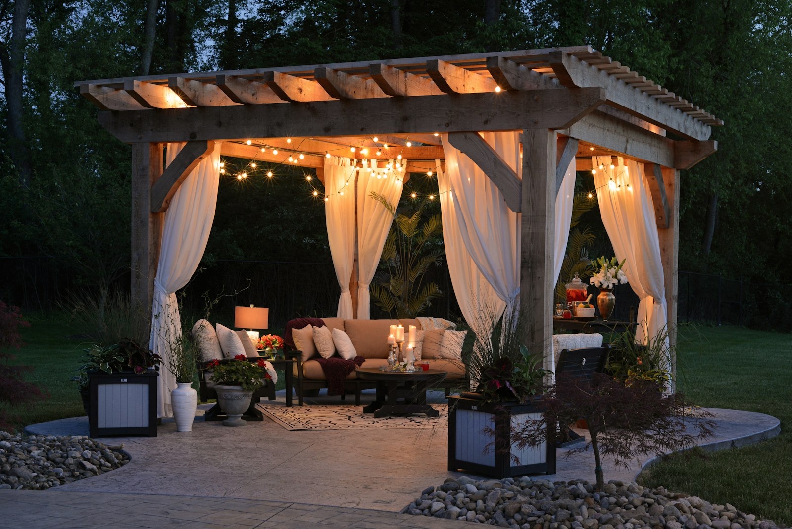 A cedar pergola with string lights over a patio at dusk