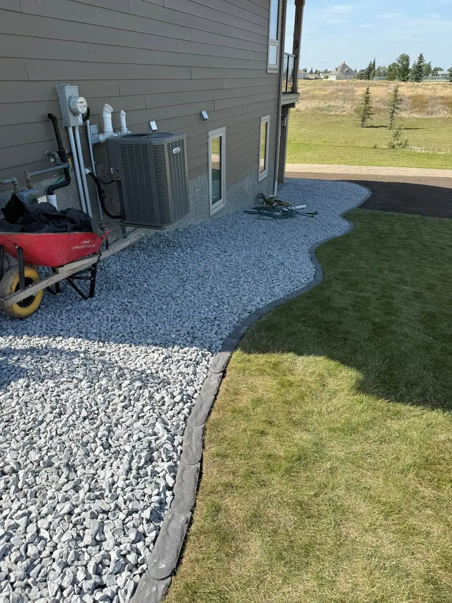 A clean rock bed and edged lawn on a maintained property