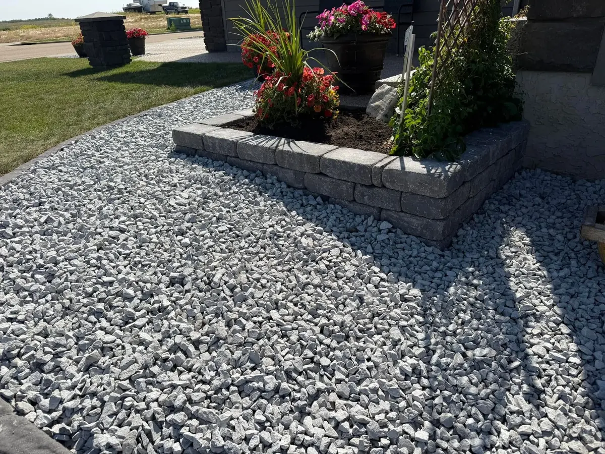 A rock bed and block border with fresh plantings along a Shakopee home