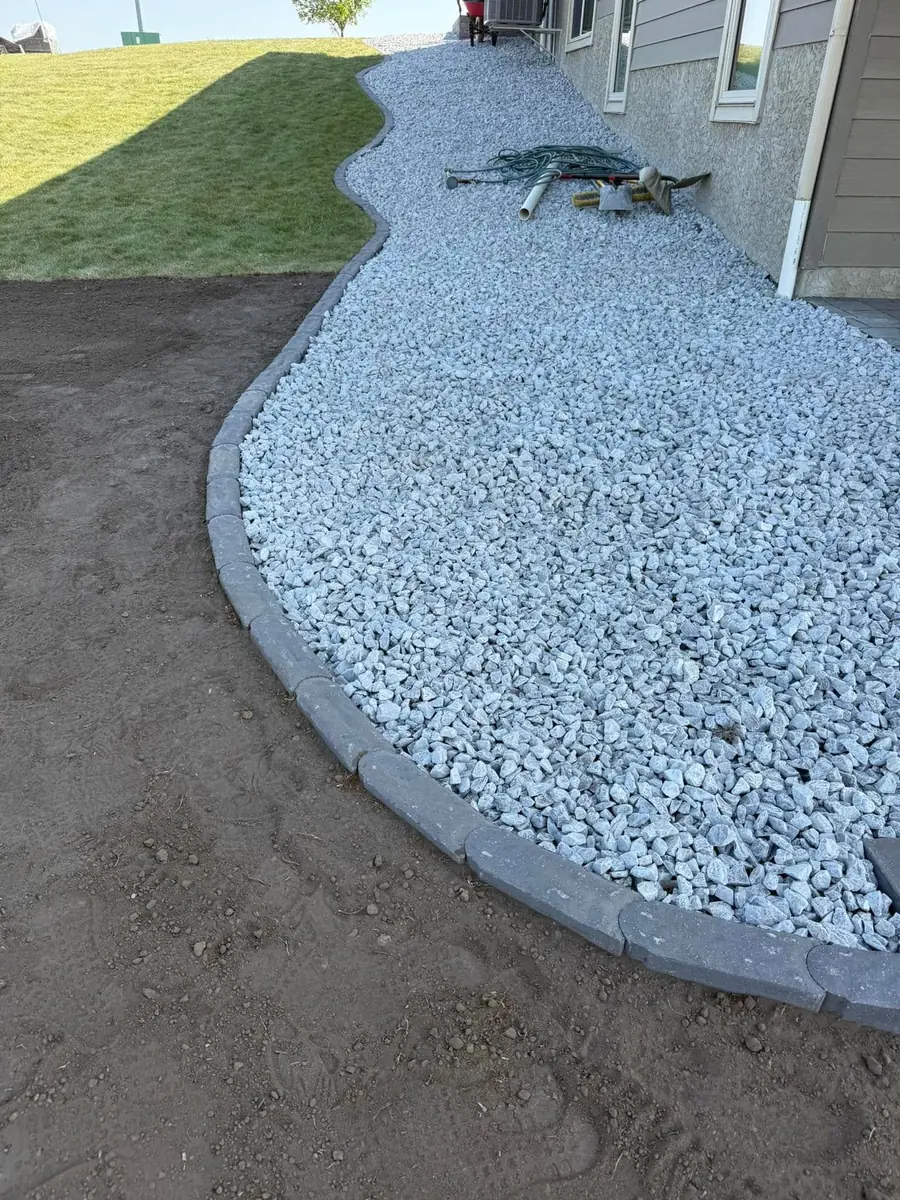 A curved rock border cut in along a freshly kept lawn