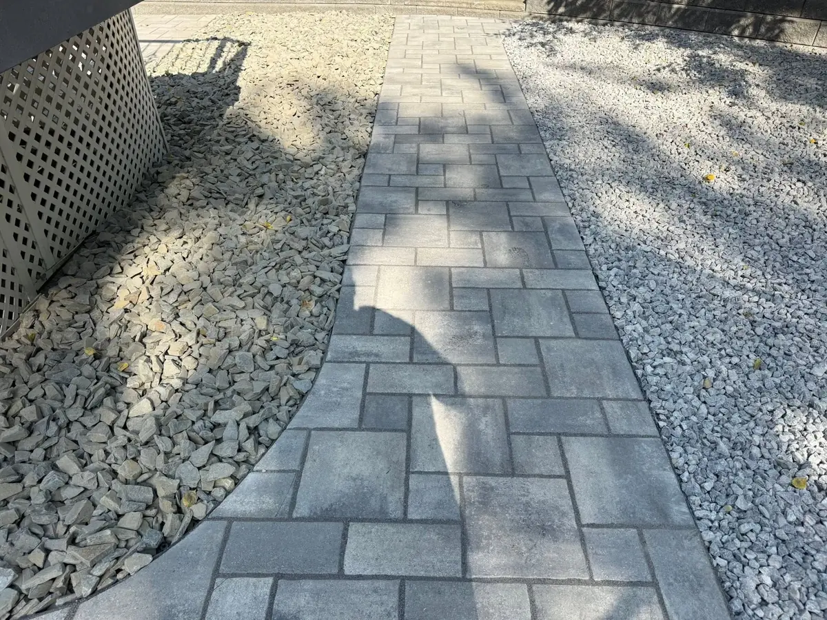 A paver walkway between river-rock beds — our own install