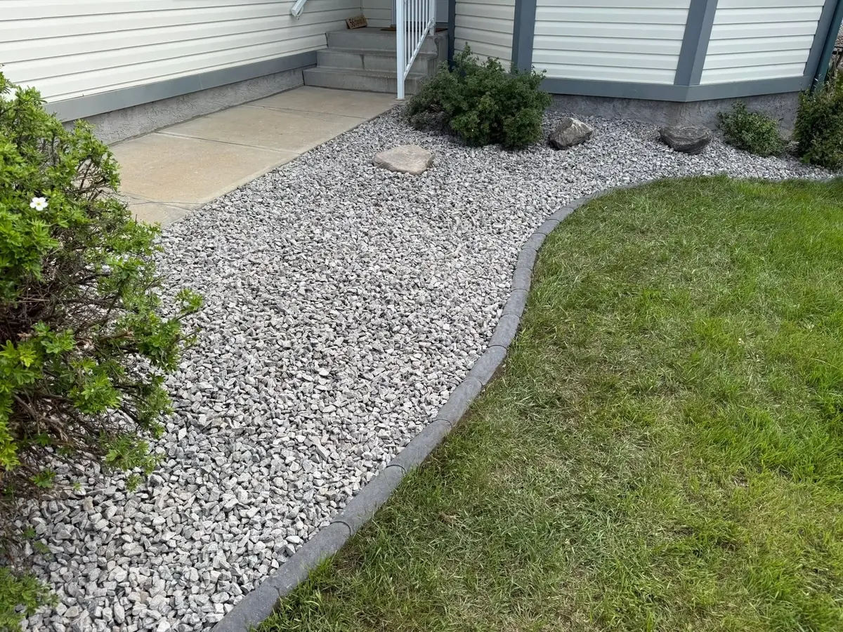 Rock beds and shrubs kept sharp along a driveway and garage