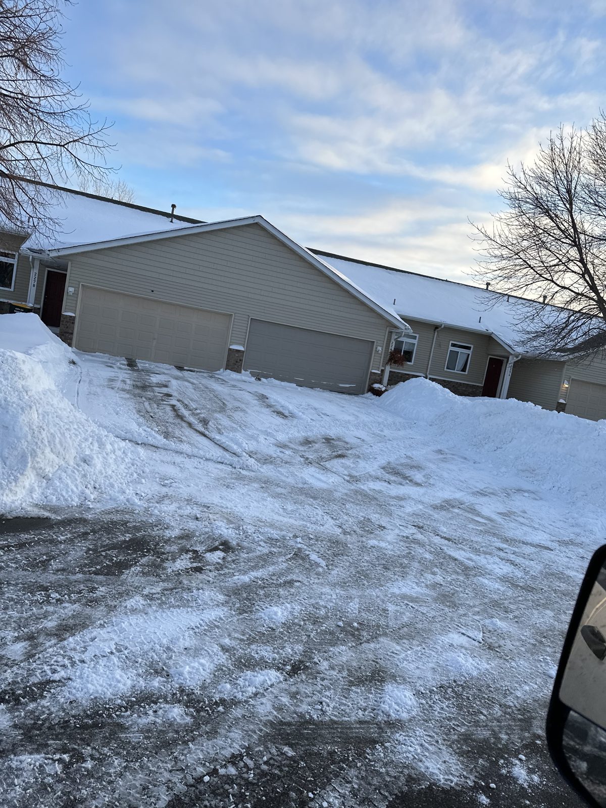 Plowed driveway with tall snow banks at a Prior Lake twin home